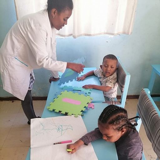 A child working on the Amharic fidel alphabet with a teacher